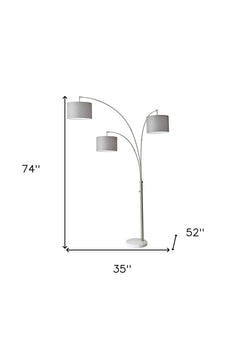 74" Brass Three Light Arc Floor Lamp With Off White Fabric Drum Shade