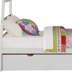 White twin over full solid wood bunk bed featuring stairs, a trundle, and storage drawer, with colorful bedding and pillows.