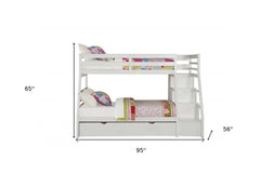 White twin over full solid wood bunk bed with stairs, trundle, and storage drawers, featuring colorful bedding and a modern d