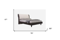 Solid wood king bed with tufted beige faux leather upholstery and nailhead trim. Dimensions: 47" H x 79" W x 80" L.