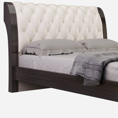 Solid wood king bed with tufted beige faux leather headboard and nailhead trim, featuring a sleek dark wood frame.