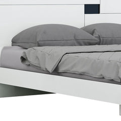 White solid wood queen bed frame with gray bedding and pillows, featuring a modern design and clean lines.