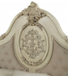 Antiqued white solid wood tufted upholstered linen bed frame with ornate floral carvings on the headboard.