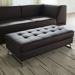 63" Brown and Silver Faux Leather Tufted Ottoman with a sleek design and chrome legs, placed in a modern living room setting.