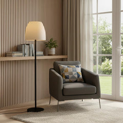 60" black and white metal floor lamp with a white bowl shade, placed next to a gray armchair in a cozy, well-lit room.