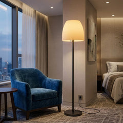 60" black and white metal floor lamp with a white bowl shade, placed next to a blue armchair in a modern room setting.
