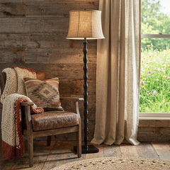 62" brown and black floor lamp with a beige burlap shade, set beside a cozy chair in a rustic room with natural light.