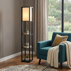 72" black and white solid wood column lamp with white cotton shade, featuring shelves and a cozy teal armchair nearby.
