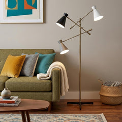 71" Brass Metal Novelty Floor Lamp featuring black and white iron cone shades, positioned next to a green sofa with colorful 