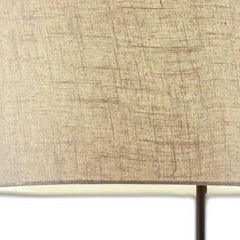 Beige fabric drum shade of a 64" tray table floor lamp with a black base, showcasing a textured design.