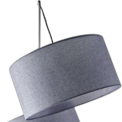 Gray linen drum shade of a three-light floor lamp, showcasing a modern design with a silver base.