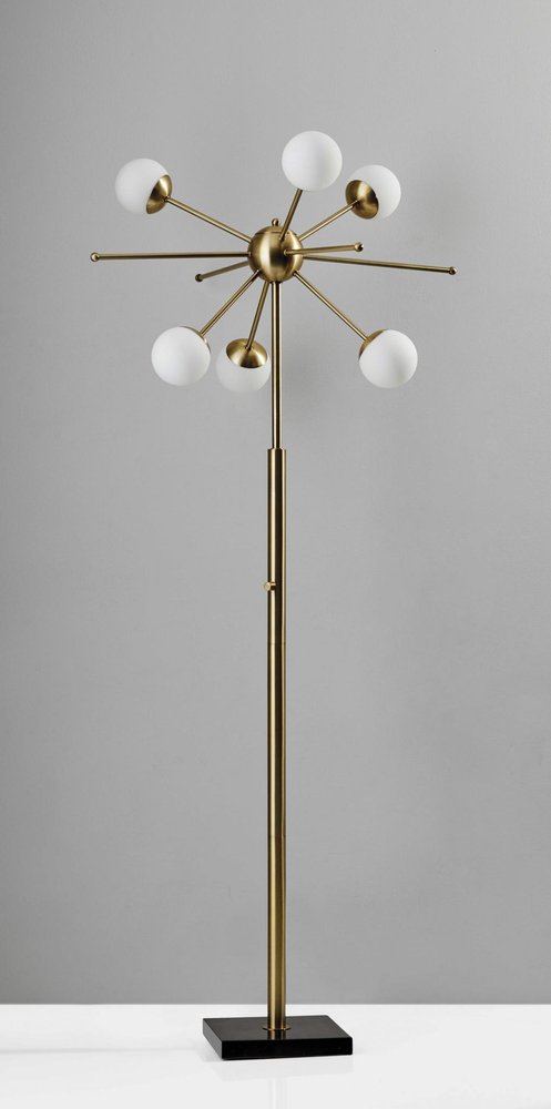 Brass six-light floor lamp with round white glass globe shades.