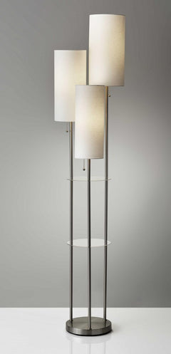 68" Silver Three Light Novelty Floor Lamp featuring white linen cylinder shades and a sleek design with a glass shelf.