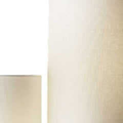 Silver three light floor lamp with white linen cylinder shade, showcasing a sleek design and elegant lighting.