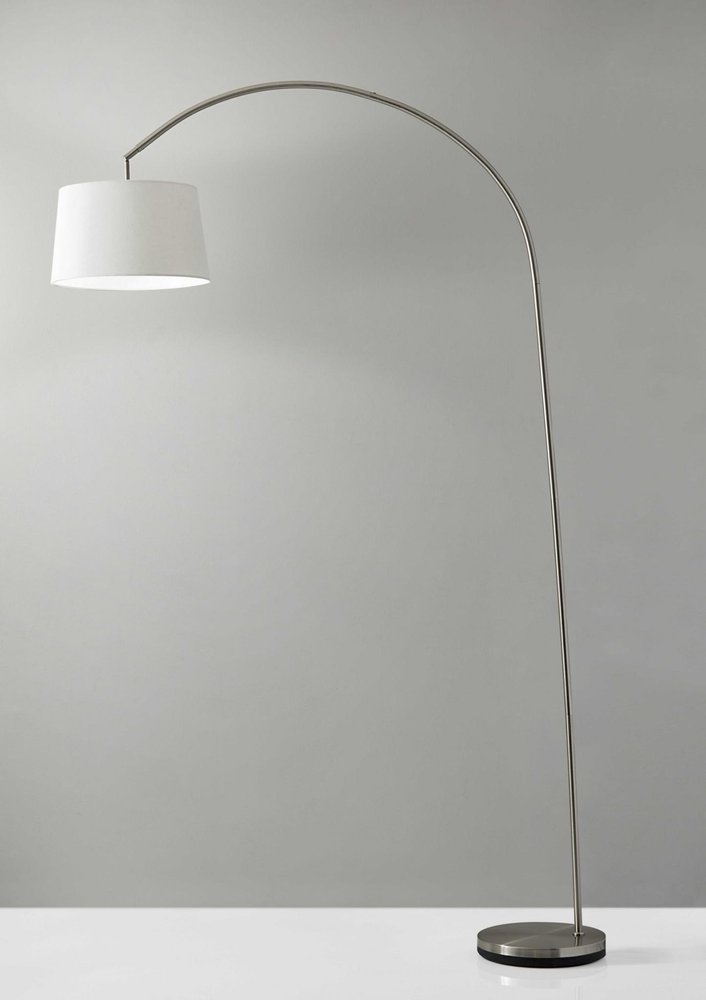 Silver arc floor lamp with a brushed metal base and white linen empire shade.