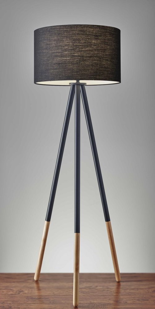 Black Metal Tripod Floor Lamp with a black fabric drum shade and wooden accents, set against a neutral background.