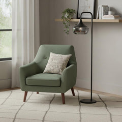 64" Black Task Floor Lamp with a sleek black glass bowl shade beside a green armchair with a patterned cushion in a cozy room