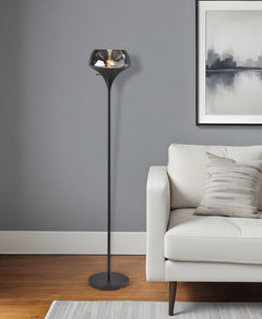 70" black floor lamp with a black glass shade, featuring a sleek design, placed next to a modern couch in a stylish room.