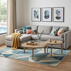 Set of two brown solid wood round nested coffee tables in a modern living room with a gray sectional sofa and colorful decor.