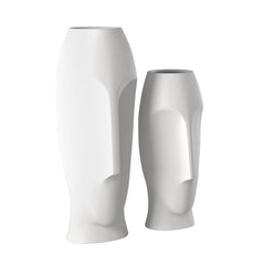 Set of two ceramic white cylinder table vases with abstract face designs, featuring smooth, modern shapes.