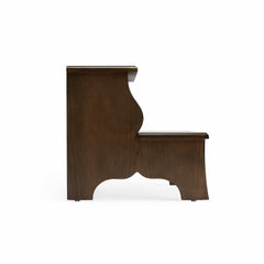 Solid wood step stool used as a footrest in living room – warm brown veneer finish detail