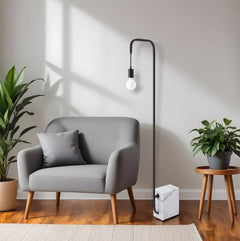 59" Black and White Steel LED Floor Lamp with a marble base, beside a gray sofa and plants in a modern living room setting.