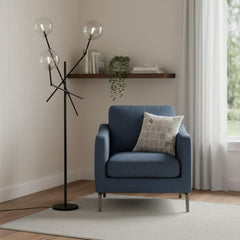 84" Black LED Floor Lamp with White accents, featuring three globe lights, beside a blue armchair in a cozy interior setting.