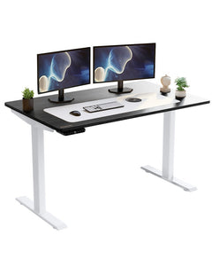 Adjustable black and white wood and stainless steel rolling computer desk with dual monitors, keyboard, and decorative plants