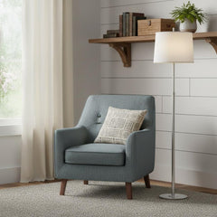 62" Floor Lamp with White Fabric Empire Shade beside a cozy blue armchair and a wooden shelf with decor.