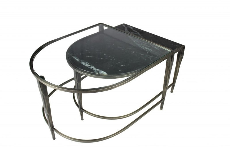 Set of two clear and gold glass and iron oval frame nested coffee tables with a sleek design and marble-like surface.