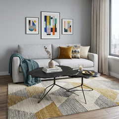 Set of two brown stone and iron free form bunching coffee tables in a modern living room with a gray sofa and decorative pill