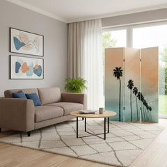 Light green folding three-panel screen room divider with palm tree design, set in a modern living room with a sofa and coffee