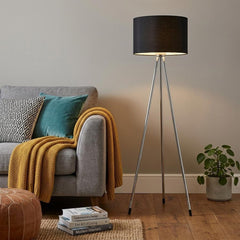 59" Silver Tripod Floor Lamp with Black Fabric Drum Shade, featuring a modern design beside a cozy sofa and decor elements.