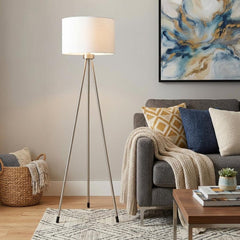 59" White Tripod Floor Lamp with White Drum Shade, featuring a sleek design beside a cozy couch and decorative elements.