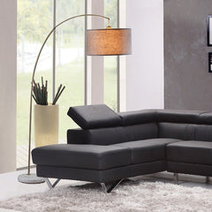 86" beige and antique gold arched floor lamp with gray drum shade, positioned beside a modern black sectional sofa.