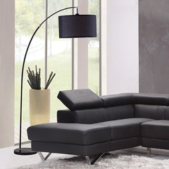 86" Black Metal Arc Floor Lamp with a black fabric drum shade, elegantly positioned beside a modern black leather sectional s