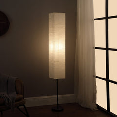 63" black and off-white column floor lamp with a rectangular off-white paper shade, providing soft ambient lighting.
