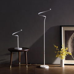 51" White LED Novelty Floor Lamp with a sleek, modern design, featuring a curved shape and a minimalist base, beside a decora