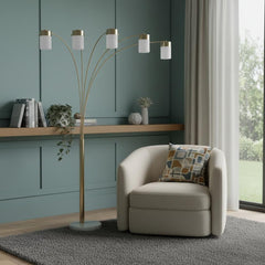 84" Gold and White Five Light Arched Floor Lamp with White Acrylic Drum Shade, featuring a modern design beside a cozy armcha