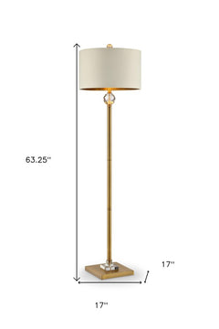 63" gold column floor lamp with off-white metal drum shade and crystal accent. Dimensions: 63.25" height, 17" square base.
