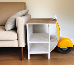 Yellow Wood And Metal Mini Scooter End or Side Table featuring a rustic wood top and white frame, styled next to a sofa.