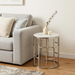 Stylish Silver And White Marble Round Geometric End or Side Table with a sleek metal base and marble top, placed beside a gra
