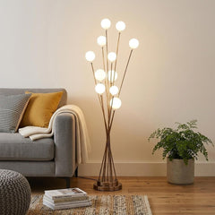 46" Gold 11 LED Novelty Floor Lamp with White globes, featuring a modern design, placed beside a cozy sofa and a plant.