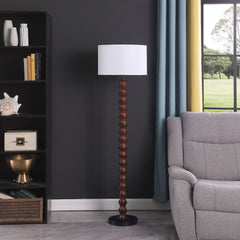 61" brown and white resin floor lamp with a white fabric drum shade, placed beside a gray sofa and a black bookshelf.