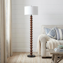 61" brown and white resin floor lamp with a white fabric drum shade, featuring a textured base and placed next to a cozy sofa