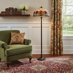 62" Brown Two Light Traditional Floor Lamp featuring a stained glass dome shade with red flowers, beside a green armchair and