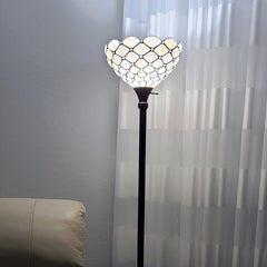 62" brown and white floor lamp featuring a white glass bowl shade with a decorative pattern, set against sheer curtains.