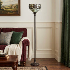 62" beige torchiere floor lamp featuring a glass dome shade with red and white flowers, set beside a cozy sofa.