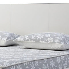 White wood and faux leather king bed frame with USB ports, featuring a sleek headboard and floral-patterned bedding.