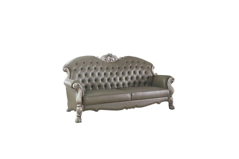 Bone faux leather sofa with toss pillows and white legs.